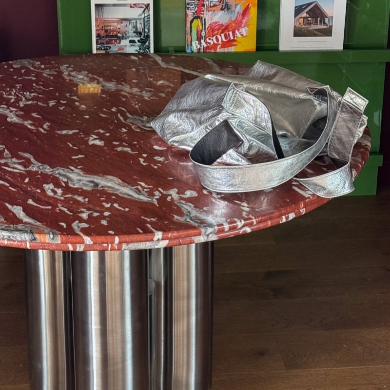 Red veined marble tabletop with silver bag & art prints behind - stylish contemporary accent furniture