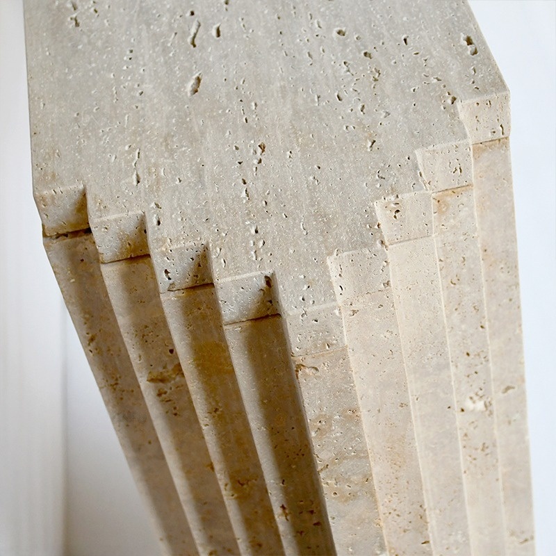 Layered travertine console table styled in modern entryway with dried flowers